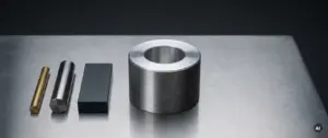 CNC-gedrehtes Aluminiumteil mit Drehrillen neben Messing-, Edelstahl- und eloxierten Materialproben auf dunklem Untergrund.
